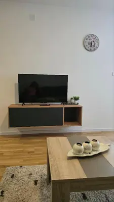 a living room with a tv and a coffee table at Luxe Apartman Sokobanja in Soko Banja