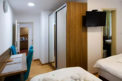 a room with a table and a bed and a mirror at Sobe Lucky in Ribarska Banja
