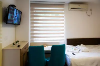 a room with a bed and a desk with two chairs at Sobe Lucky in Ribarska Banja