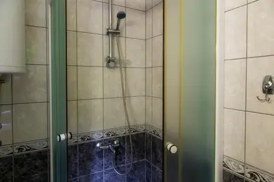 a shower with a glass door in a bathroom at Sobe Lucky in Ribarska Banja