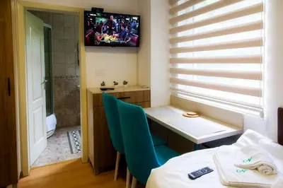 a room with a table and a television on the wall at Sobe Lucky in Ribarska Banja