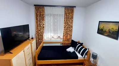 a small bedroom with a bed and a window at Spasojević Apartman in Kuršumlija