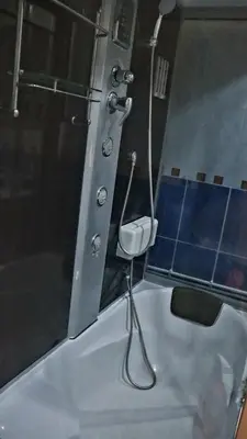 a bathroom with a shower and a stool in a tub at Spasojević Apartman in Kuršumlija