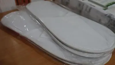 a white toilet sitting on top of a wooden floor at Spasojević Apartman in Kuršumlija