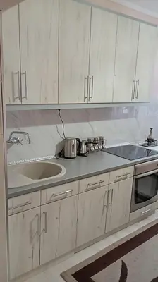 a kitchen with white cabinets and a sink at Lina apartment in Lebane
