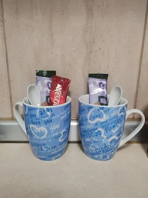 two blue cups sitting on a shelf with spoons at Happy house in Kruševac