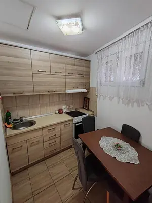 a kitchen with a wooden table and a table and a dining room at Happy house in Kruševac