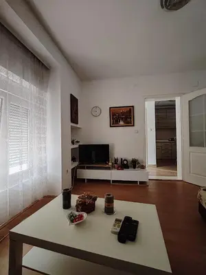 a white living room with a table and a couch at Happy house in Kruševac