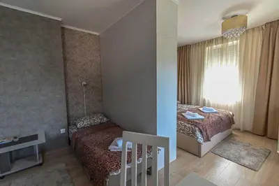 a small bedroom with two beds and a window at Zlatnik Vrnjačka Banja in Vrnjačka Banja
