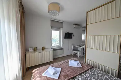 a bedroom with a large bed with two towels on it at Zlatnik Vrnjačka Banja in Vrnjačka Banja