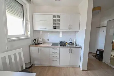 a kitchen with white cabinets and a sink and a window at Zlatnik Vrnjačka Banja in Vrnjačka Banja