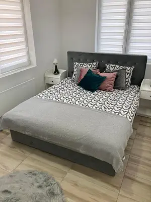 a bedroom with a large bed with pillows on it at Apartman LOKI in Soko Banja