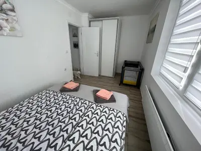 a bedroom with a bed with a black and white blanket at Apartman LOKI in Soko Banja