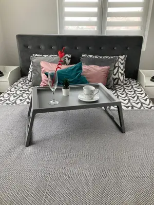 a coffee table sitting on a bed with a table at Apartman LOKI in Soko Banja