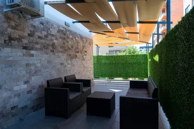 a patio with chairs and tables under a roof at Apartmani Putnik in Vrnjačka Banja