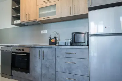a kitchen with a stainless steel refrigerator and a microwave at Apartmani Putnik in Vrnjačka Banja