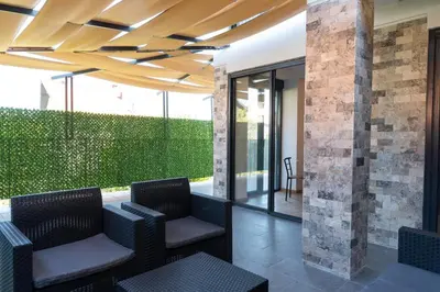 a patio with wicker chairs under a wooden ceiling at Apartmani Putnik in Vrnjačka Banja