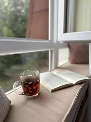 a cup of tea and a book on a window sill at Cozy Lodge Kopaonik in Kopaonik