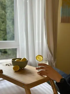 a person holding a glass of wine and a bowl of fruit at Cozy Lodge Kopaonik in Kopaonik