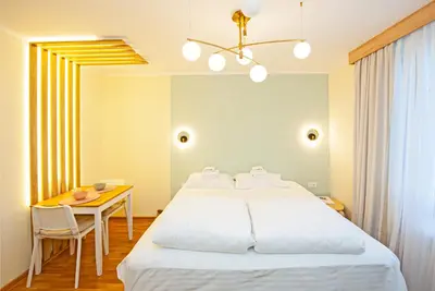 a bedroom with a large bed and a table at Cozy Lodge Kopaonik in Kopaonik