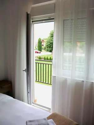 a bedroom with a sliding glass door to a balcony at Villa Nina in Vrnjci