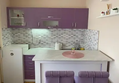 a kitchen with purple cabinets and a sink at Niki Apartman in Kruševac