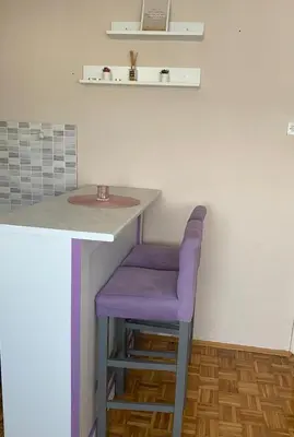a purple stool sitting under a counter in a kitchen at Niki Apartman in Kruševac