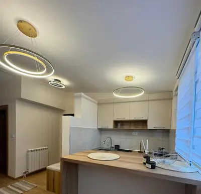 a kitchen with three lights on the ceiling at Kraljica apartman in Vrnjačka Banja