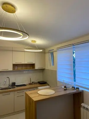 a kitchen with a counter and a sink and a window at Kraljica apartman in Vrnjačka Banja