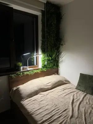 a bedroom with a bed with a window with plants at La familia Kopaonik in Brzeće