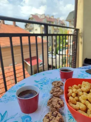 a table with cookies and cups of coffee on a balcony at Sunrise apartment Sokobanja in Soko Banja