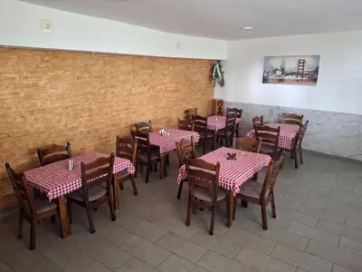 a restaurant with tables and chairs with pink and white tablecloths at Apartmani Borovi in Pirot