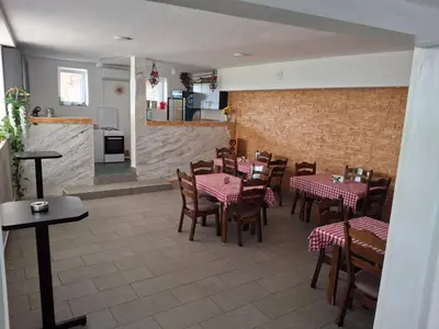 a restaurant with tables and chairs in a room at Apartmani Borovi in Pirot