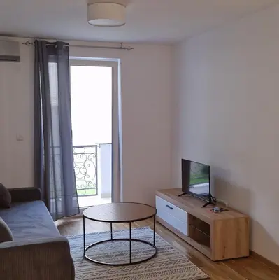 a living room with a couch and a table with a tv at MB LUX Residence in Vrnjačka Banja