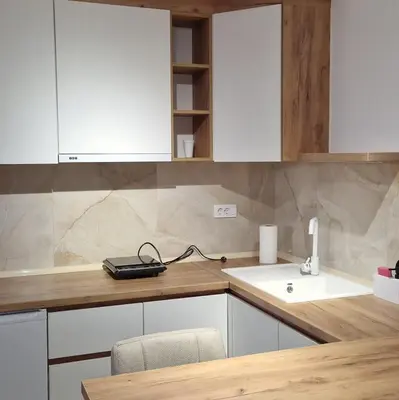 a kitchen with white cabinets and a sink at MB LUX Residence in Vrnjačka Banja