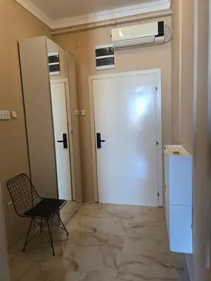 a room with a door and a chair and a fan at Red Diamond in Niš
