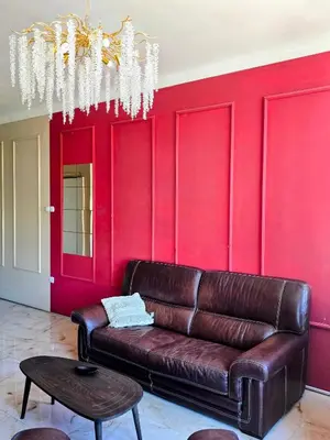 a leather couch in a room with a red wall at Red Diamond in Niš