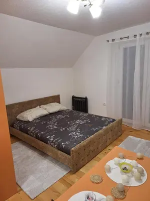 a bedroom with a bed and two tables at Vila Kojzak in Bela Stena