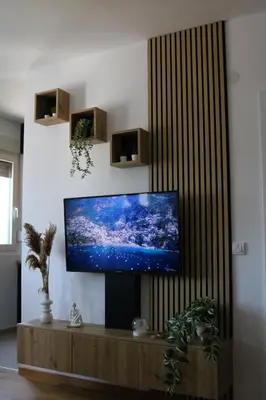 a living room with a flat screen tv on a wall at Aria Apartman Sokobanja in Soko Banja