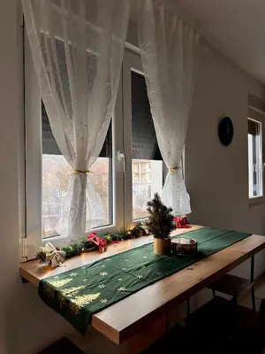 a table with a green mat in front of two windows at Aria Apartman Sokobanja in Soko Banja