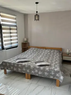 a bed in a white room with a bedspread at Miljaca in Pirot