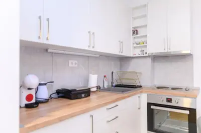 a kitchen with white cabinets and a counter top at Viktor i Kasija green hill in Soko Banja
