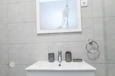 a white sink in a bathroom with a picture on the wall at Viktor i Kasija green hill in Soko Banja