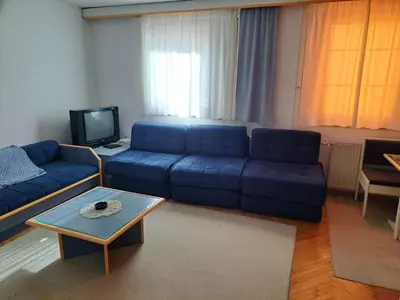 a living room with a blue couch and a coffee table at Kopaonik- Vila Ivana in Kopaonik