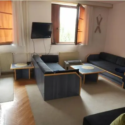 a living room with couches and a flat screen tv at Kopaonik- Vila Ivana in Kopaonik