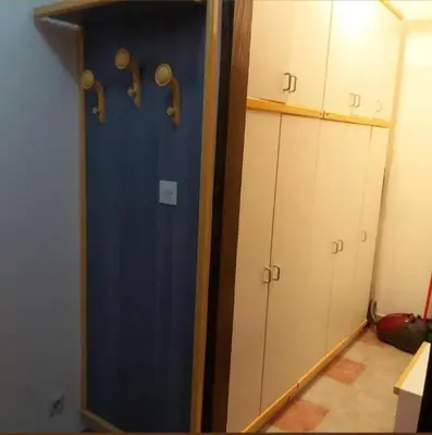 a closet with a blue door and white cabinets at Kopaonik- Vila Ivana in Kopaonik