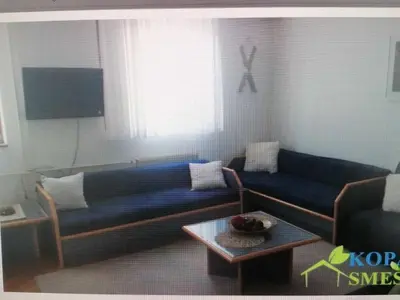 a living room with a blue couch and a table at Kopaonik- Vila Ivana in Kopaonik