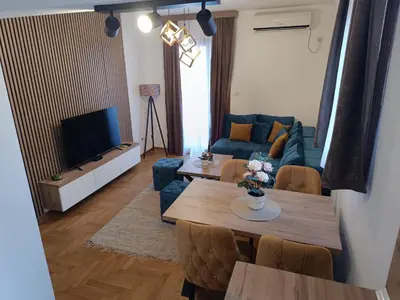 a living room with a table and a blue couch at Apartman Savić Solaris in Vrnjci
