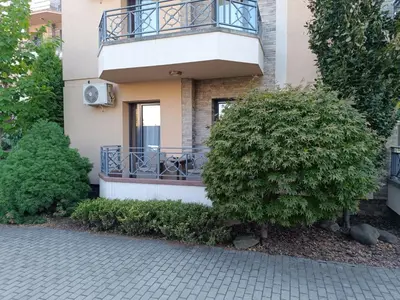 a building with a balcony and a bush at Apartman Savić Solaris in Vrnjci