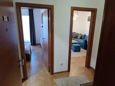 an open door to a living room with a blue couch at Apartman Savić Solaris in Vrnjci